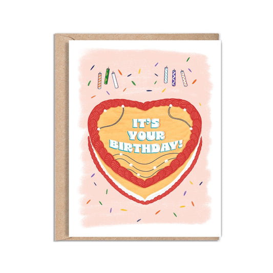 4.25 x 5.5” A2 size Birthday card illustration of a heart-shaped yellow cake with red icing. In the center of the cake are the words “It’s Your Birthday! ”with line detail and pearls along the cake. Colorful sprinkles and candles surround the cake. The textured background has soft red brush strokes over a white background. The inside of the card message reads “Happy Birthday, Hope your birthday is filled with all the things you love.”. Envelope included. Black Woman Owned.